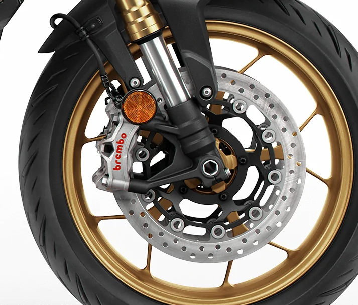 Primer plano de un sistema de frenos de motocicleta, mostrando una pinza Brembo de alto rendimiento con discos perforados en una rueda con llanta de perfil bajo.