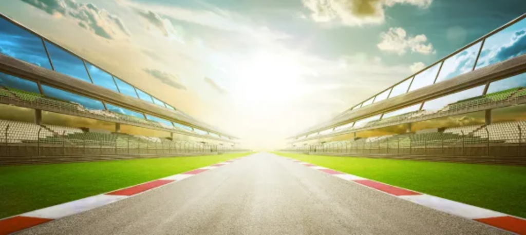 Vista panorámica de la pista de carreras de Montmeló, con gradas vacías y un sol radiante al fondo, resaltando el ambiente del Gran Premio de Cataluña.