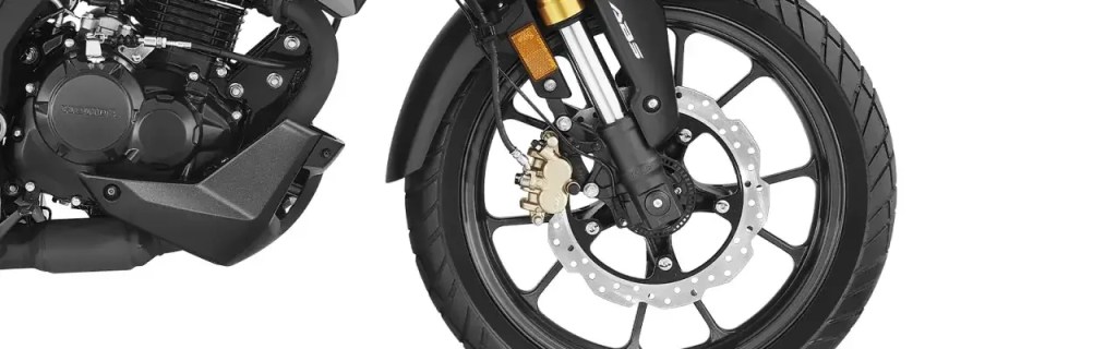 Detalle del motor y rueda delantera de una moto, mostrando el disco de freno y la suspensión.