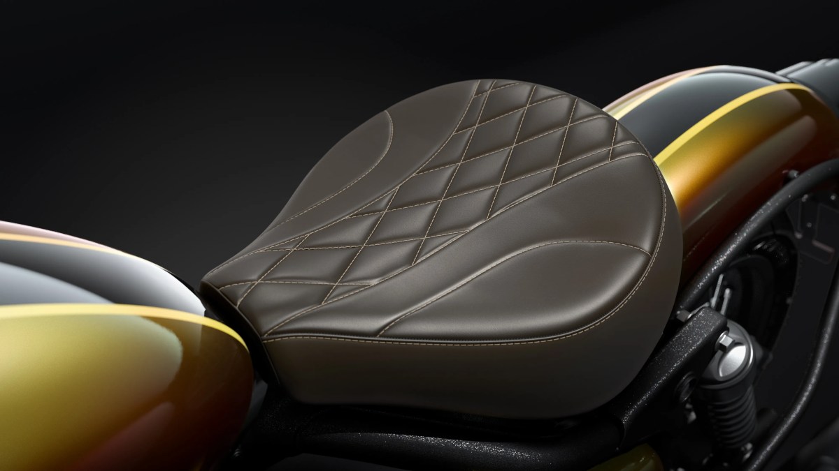 Detalle del asiento de una motocicleta Royal Enfield, con tapicería en tono marrón y diseño acolchado en forma de rombos, frente a un fondo oscuro.
