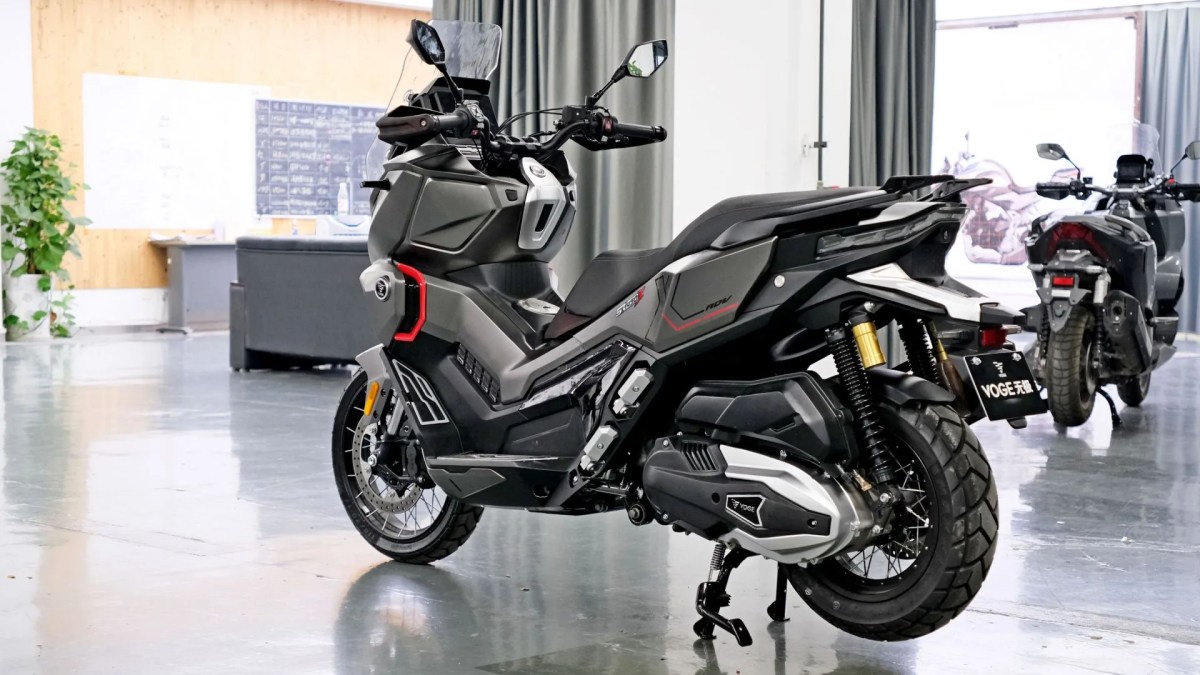 La VOGE SR450X, un scooter crossover de 398 cc, exhibido en un ambiente moderno, con un diseño funcional y detalles en rojo, ideal para la aventura urbana.