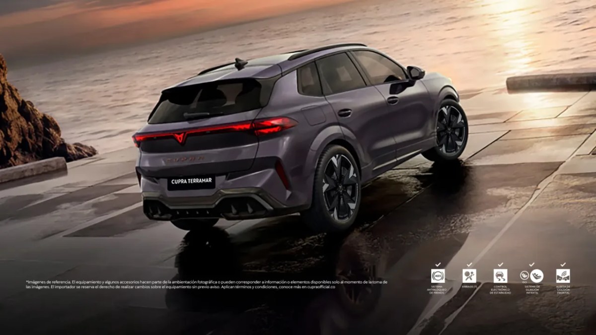 Vista trasera del CUPRA Terramar, un SUV deportivo con un diseño audaz, estacionado frente al mar al atardecer.