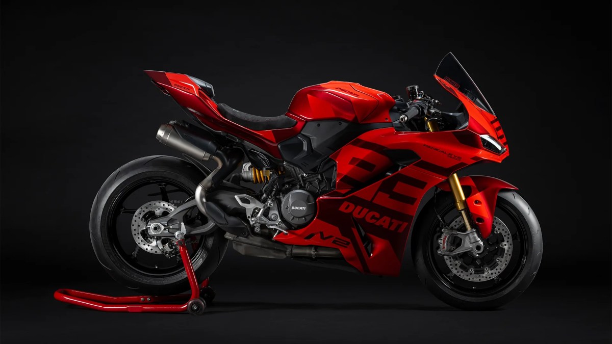 Motocicleta Ducati Panigale V2 en color rojo, destacando su diseño deportivo y moderno, con detalles en negro y un soporte de moto en la parte inferior.