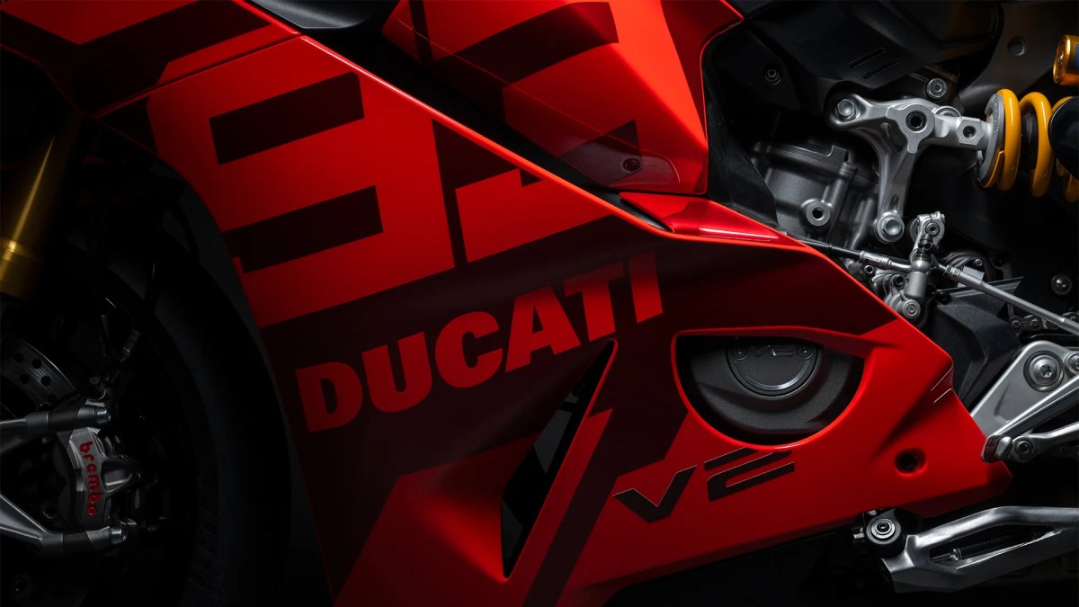 Detalle de la carrocería roja de la Ducati V2, con el logo de la marca y parte del motor visible.