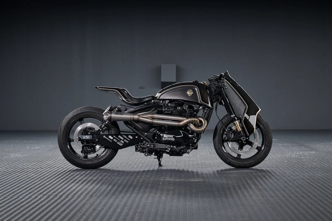 Motocicleta personalizada Royal Enfield Shotgun 650, con un diseño negro y detalles artesanales, exhibida en un fondo gris.