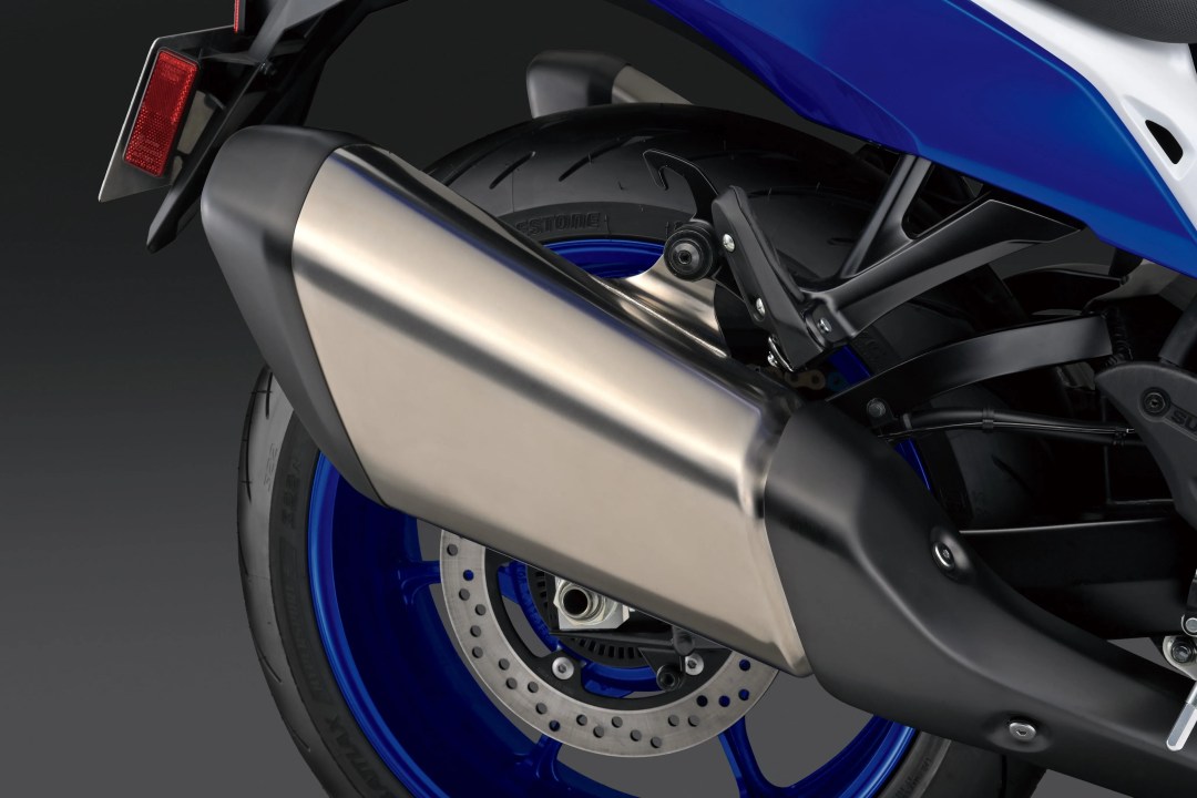 Detalle del escape de la Suzuki Hayabusa 2026, mostrando su diseño elegante y el neumático trasero de alto rendimiento, con llantas azules que complementan la estética de la moto.