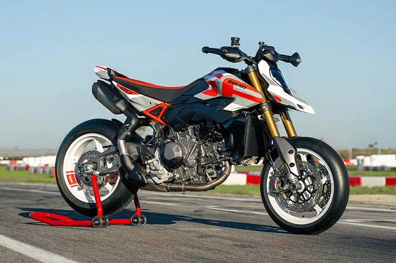 Ducati Hypermotard V2 2026 in a parking lot, showcasing its sleek design with a V2 engine and updated electronic package.