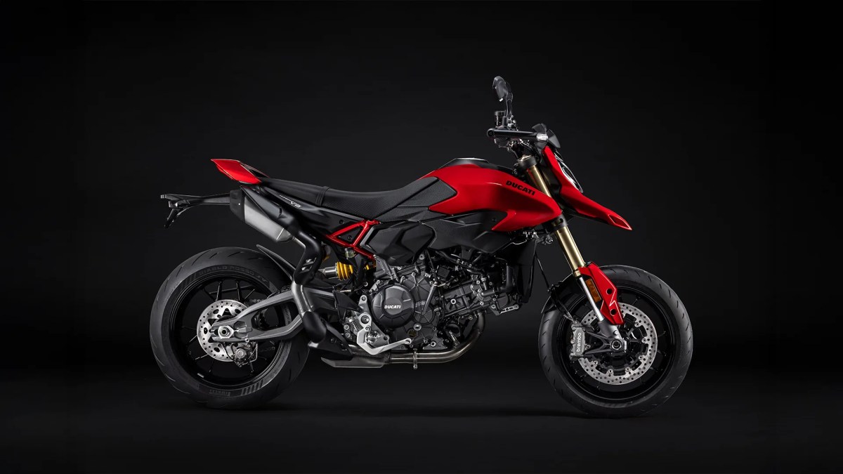 Moto Ducati Hypermotard V2 de color rojo en un fondo negro, mostrando su diseño moderno y agresivo.